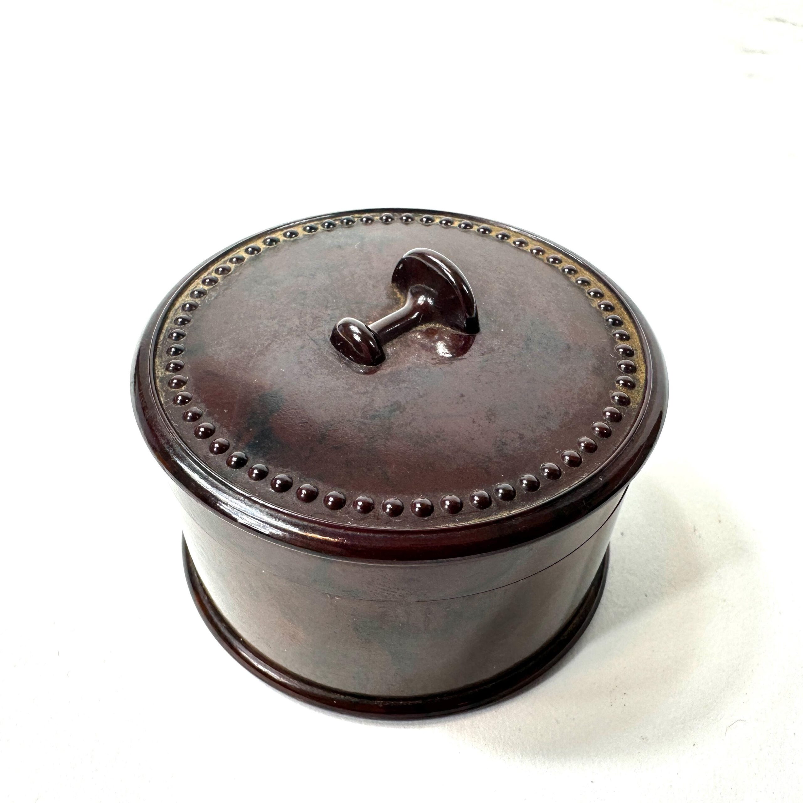 1930s marbled brown Bakelite cufflink box with Art Deco beaded lid and geometric handle, front view