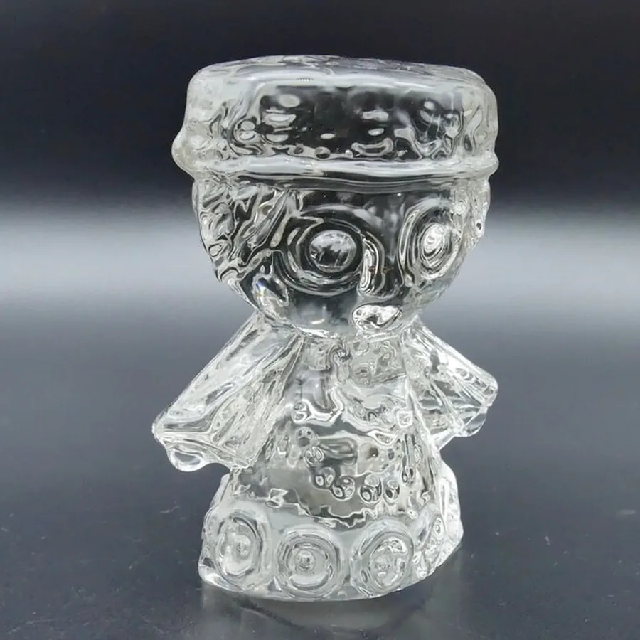 Angel figurine three-quarter view showing ornamental base and costume silhouette in crystal