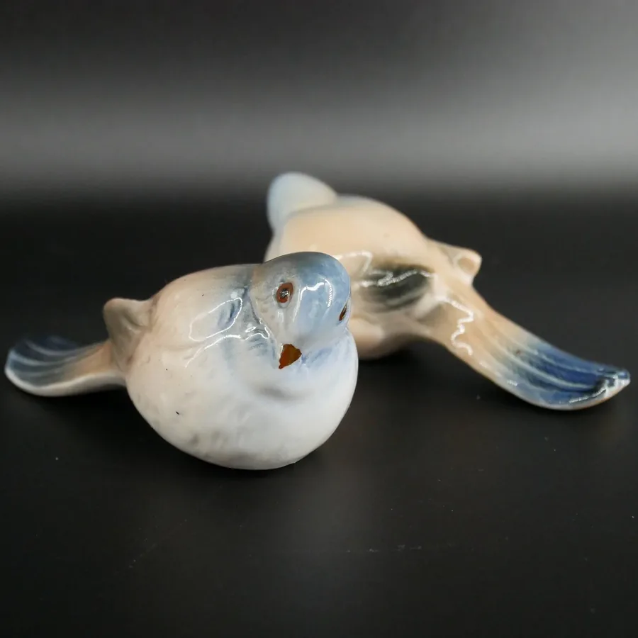 Bing & Gröndahl Danish porcelain bird figurine with cream glaze, blue-grey wings, and hand-painted details, shown in profile