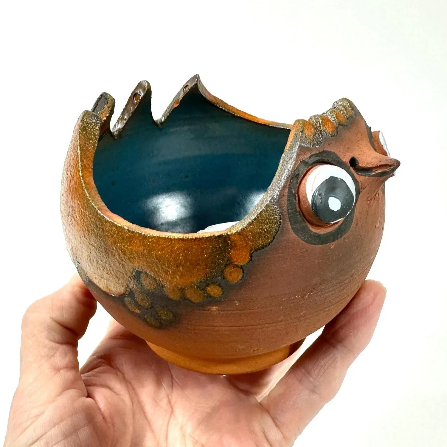 Björn Keramik Danish chicken bowl held in hand, terracotta with blue glazed interior and expressive glass eyes