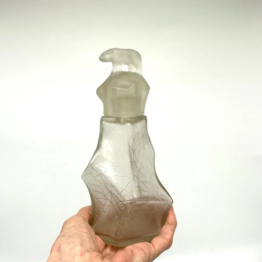 Bottom view of vintage TeZHe polar bear perfume bottle showing base marking, pontil scar, and maker's signatures or productio