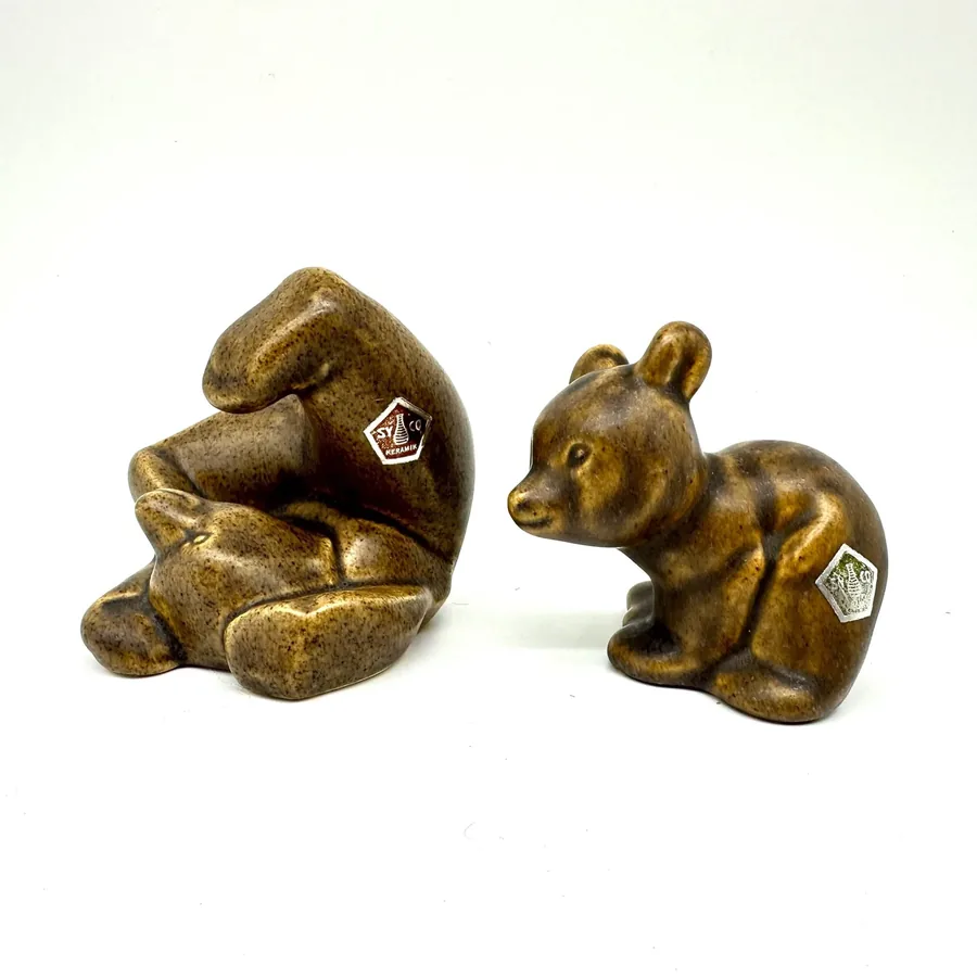 Ceramic bear figurines showing detail of maker's mark pentagon stamps and glazed surface finish on seated and playful poses