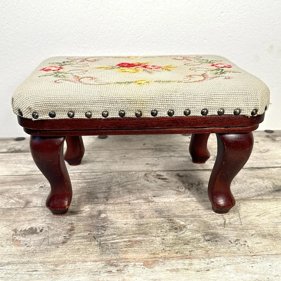 Close-up of vibrant needlepoint floral embroidery showing intricate stitching patterns and color palette