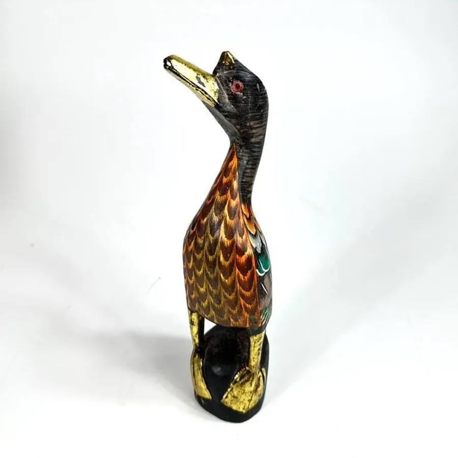 Close-up of wooden duck's head and neck showing hand-painted details and gold gilding accents