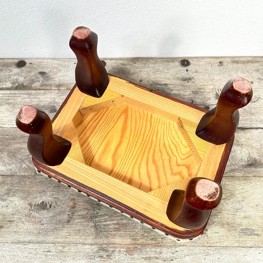 Elevated angle of vintage embroidered footstool showing textile surface quality and floral pattern comprehensively