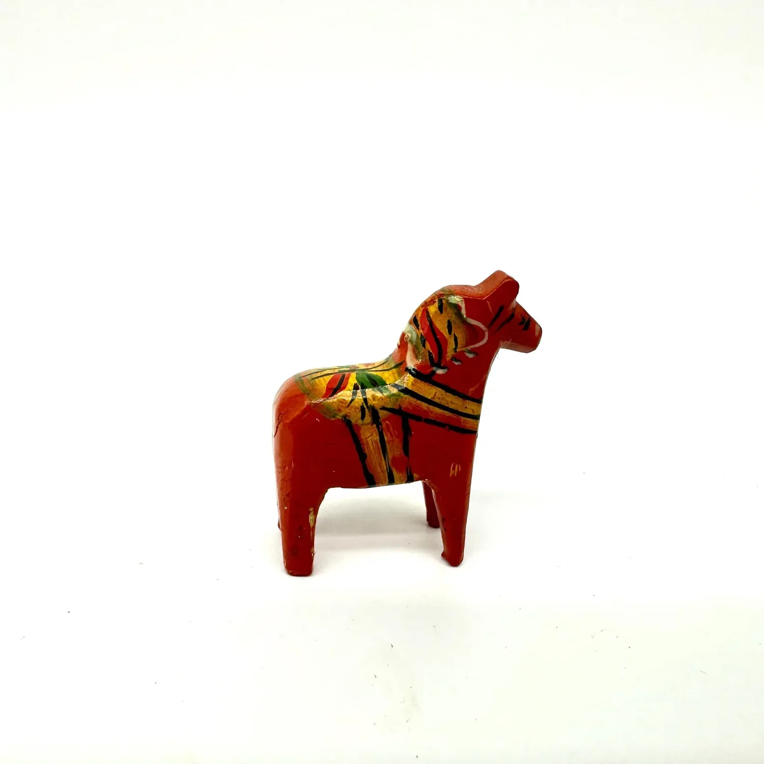 Hand-carved Dala horse by Nils Olsson, vibrant red wooden body with traditional white kurbits floral painting, miniature Swed