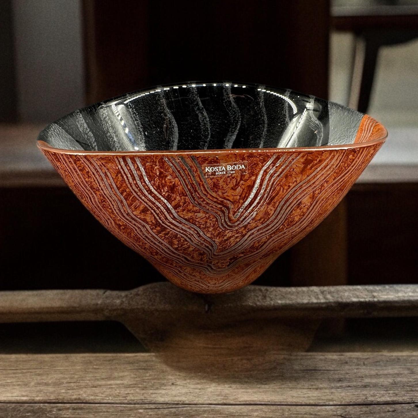 Kosta Boda Tonga art glass bowl by Monica Backström, hand-blown Swedish 1980s design with warm amber wood grain exterior and