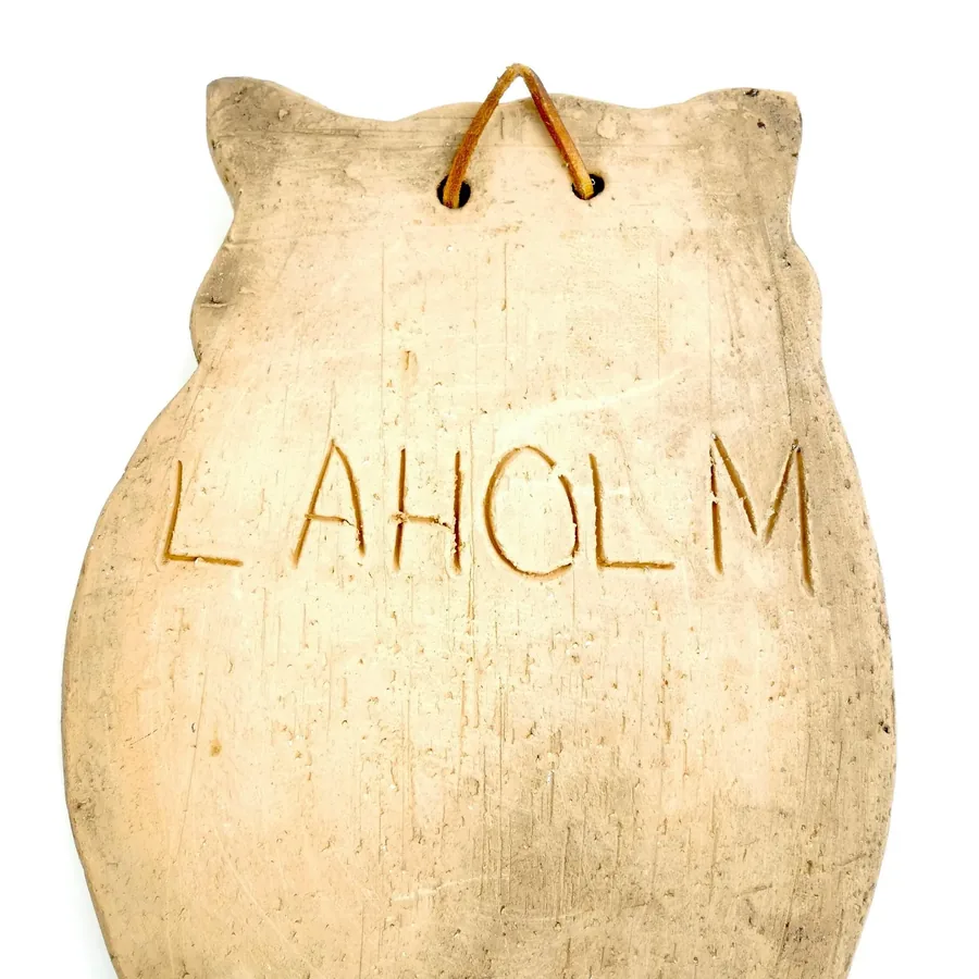 Laholm owl back panel showing carved Laholm signature, cream ceramic finish, wall mounting preparation