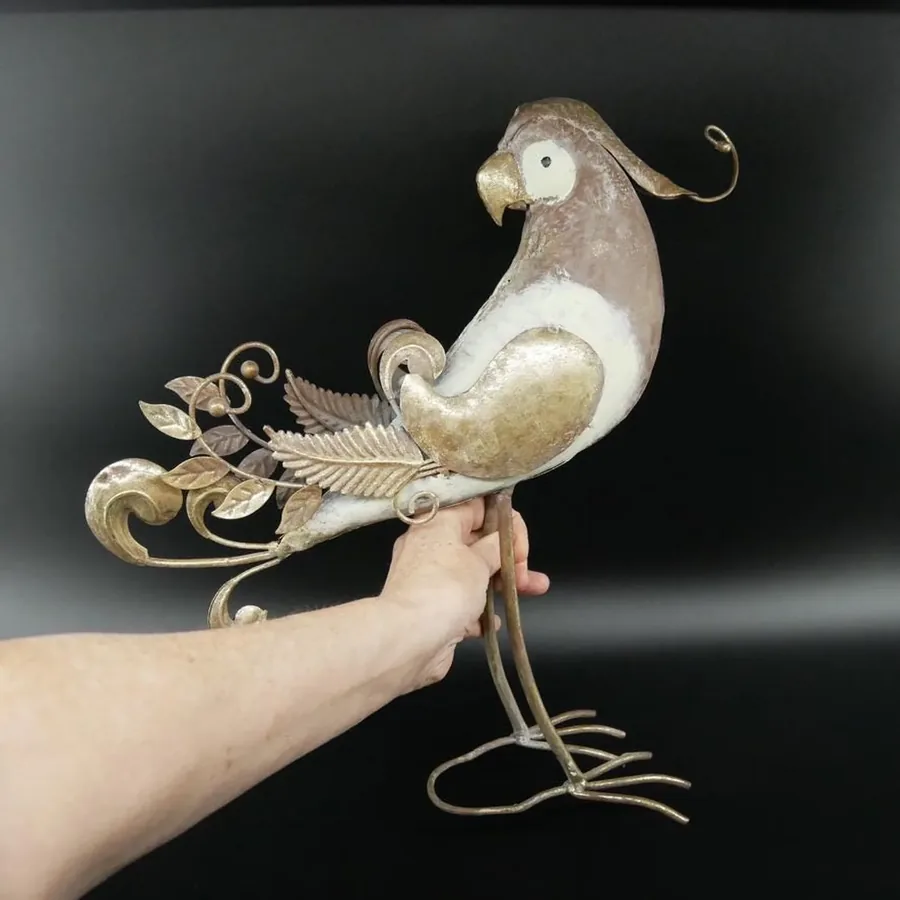 Metal parrot sculpture held in hands showing scale, weight, and impressive 17-inch height with intricate detailing