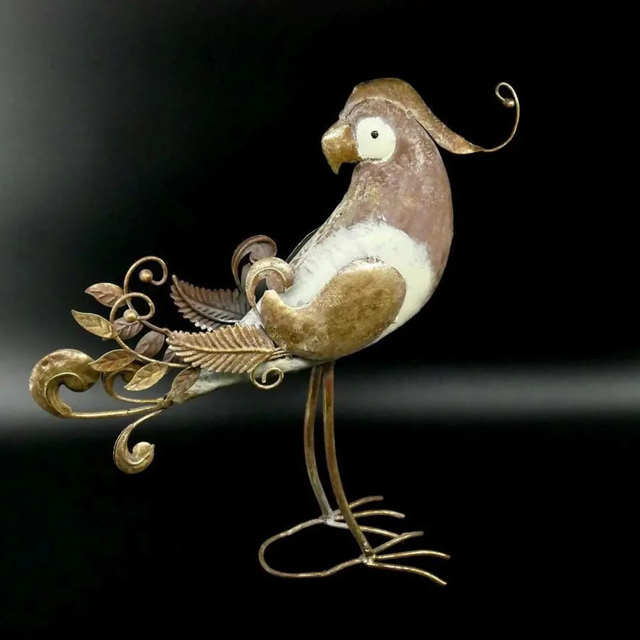 Metal parrot sculpture viewed from angle showing full body profile with extended tail and graceful leg stance