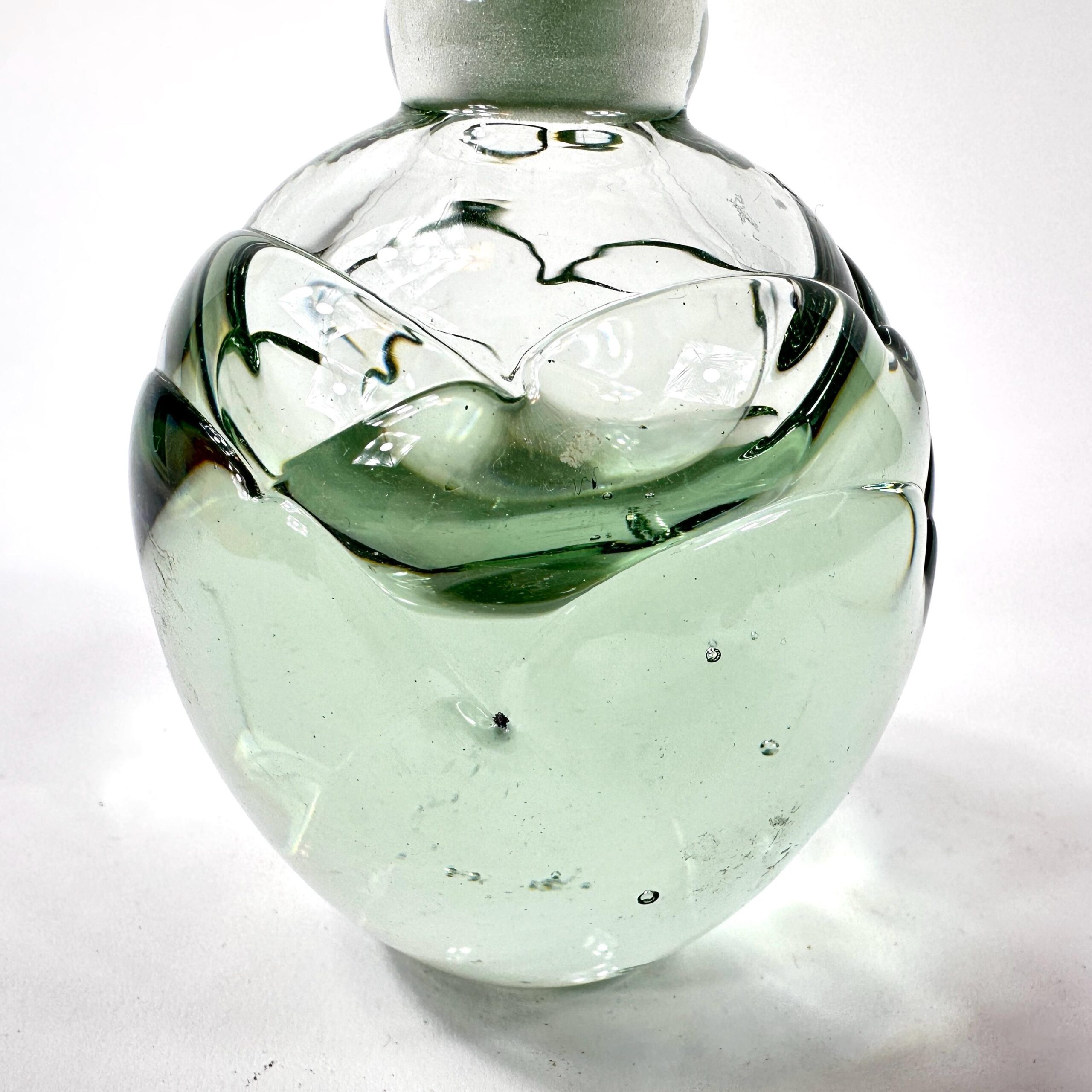 Perfume bottle rear view showing organic petal curves and artistic glass shaping
