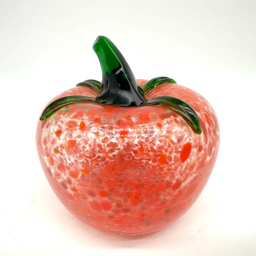 Red speckled glass tomato front view showing round form with prominent green stem detail