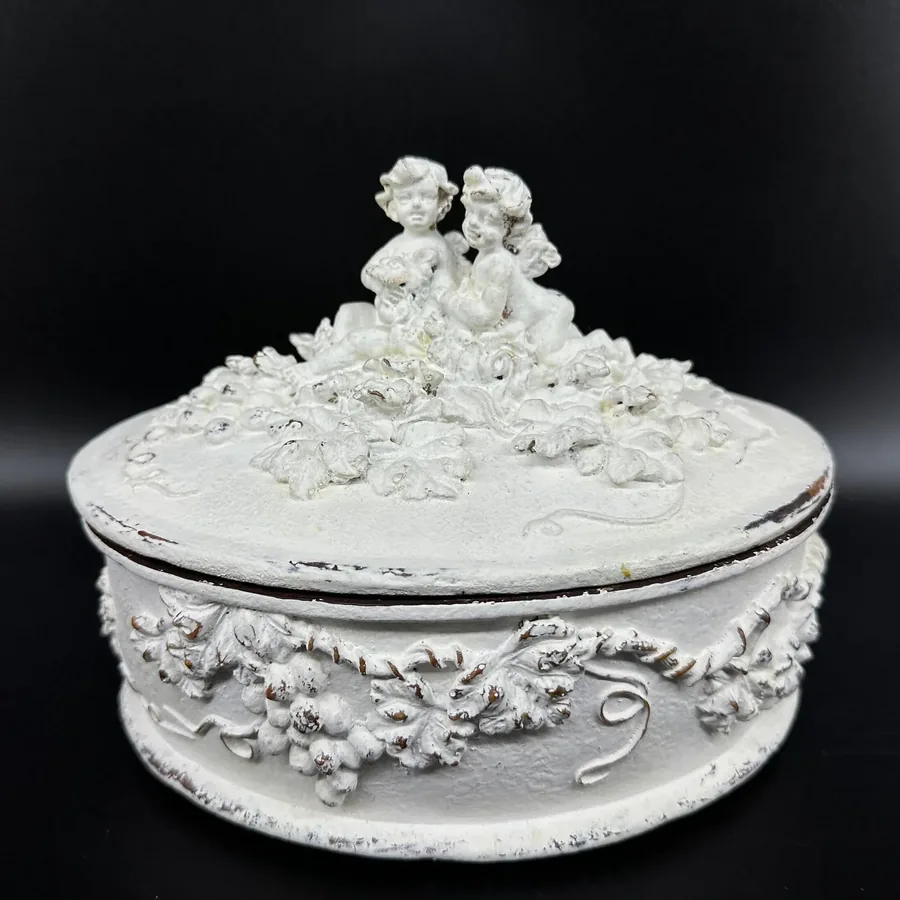 Rococo white wooden box with paired cherub sculpture and layered carved border, centered display angle