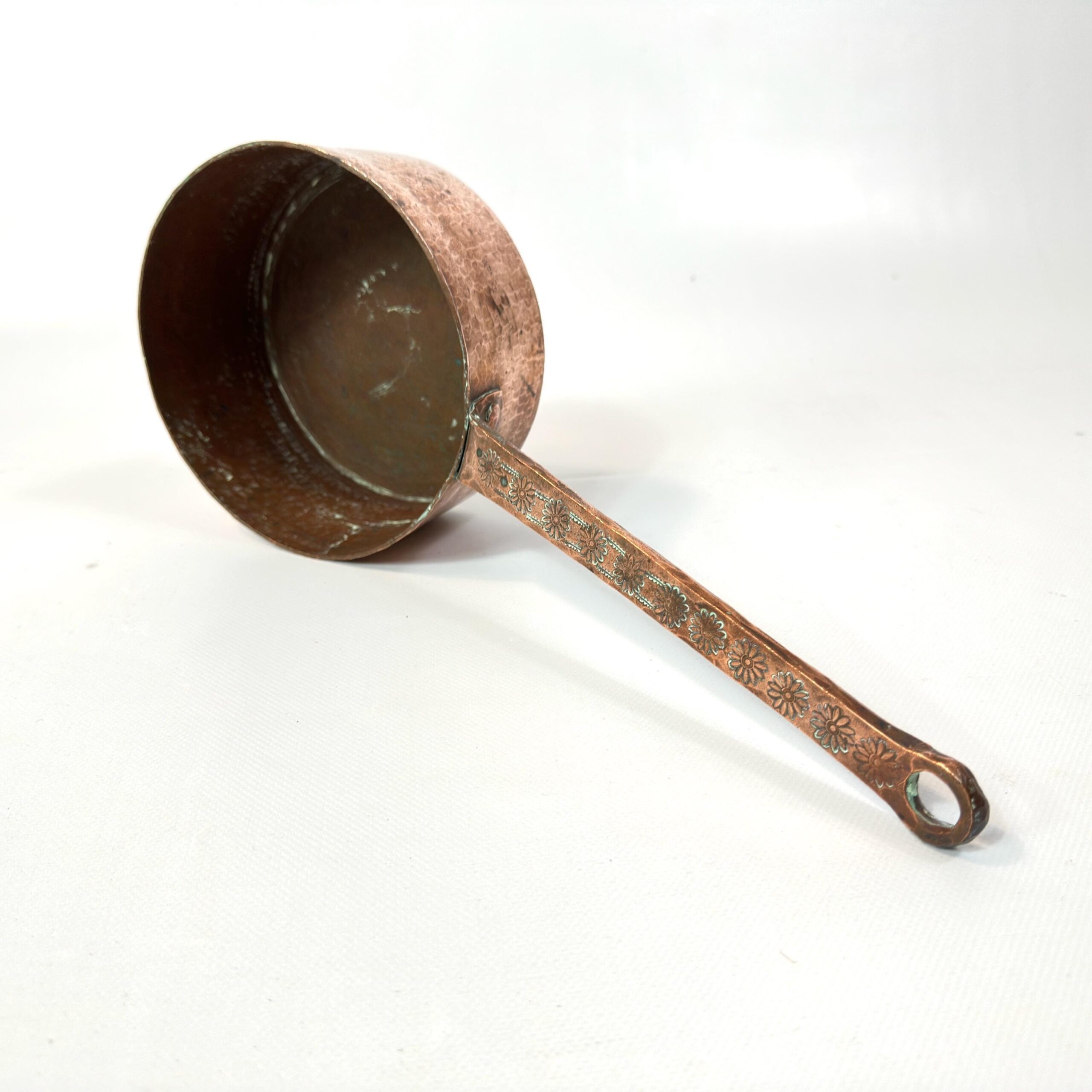 Saucepan with lid or comparative view showing scale and vintage copper patina in soft lighting conditions
