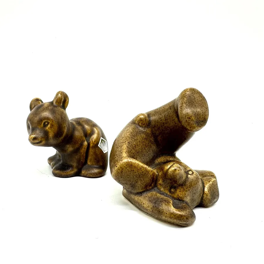 Side profile of ceramic bear set showing sculptural proportions, tumbling arrangement, and warm aged patina throughout