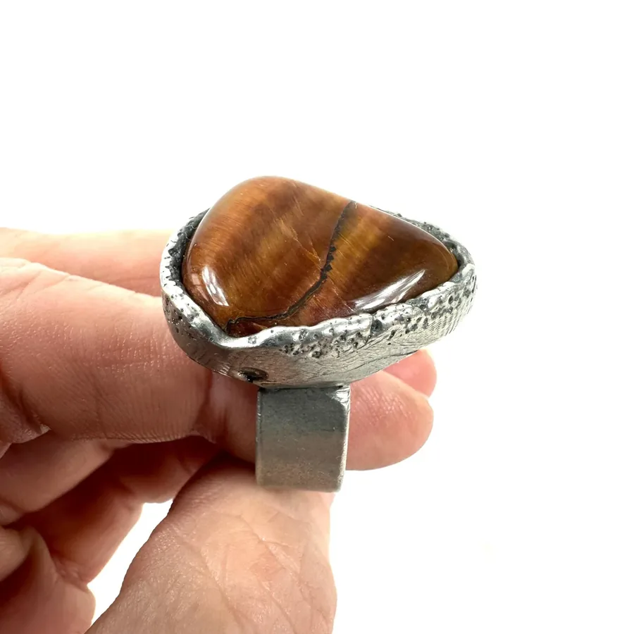 Top-down view of Tiger's Eye stone, full face showing chatoyancy effect and golden striations pattern