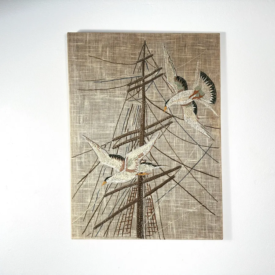 Vintage 1960s-70s embroidered maritime wall art featuring hand-stitched seagulls and ship mast on natural linen, museum-frame