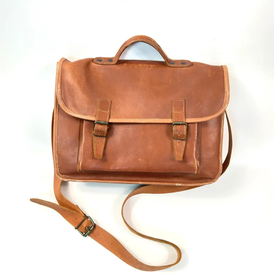 Vintage brown leather satchel with double buckle closure, chestnut full-grain hide, padded handles, front view