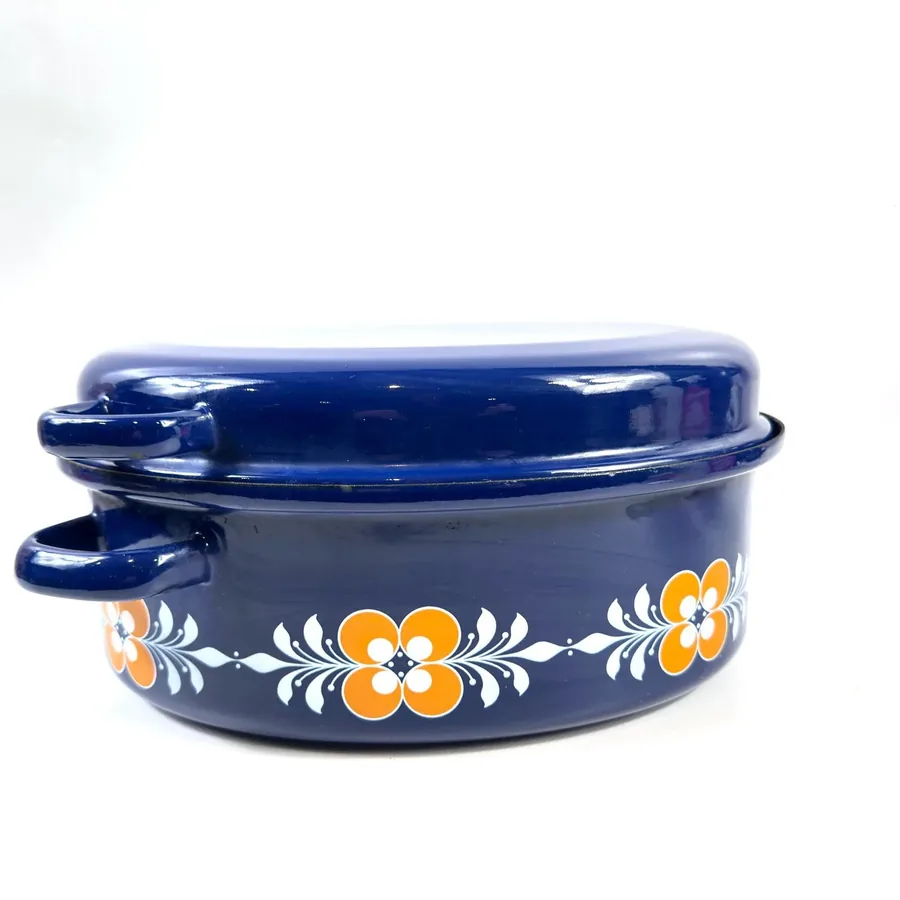Vintage cobalt blue enamel casserole with orange-white floral motifs and matching lid, 1960s-70s retro design