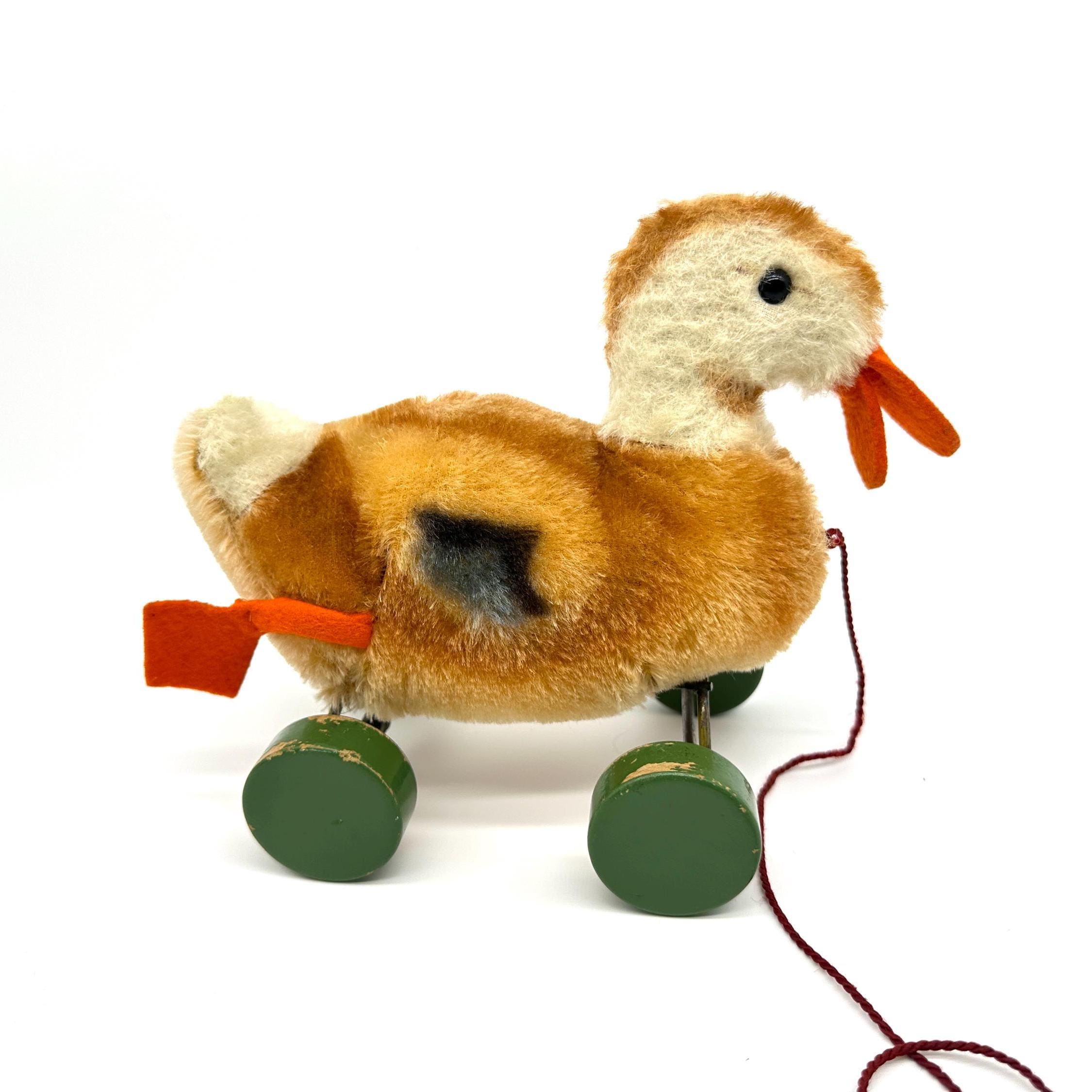 Vintage Steiff pull duck displayed stationary showing complete toy assembly with ribbon, wheels, and pull string visible