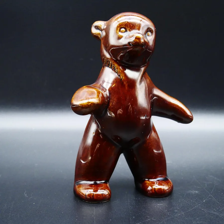 Vintage Swedish ceramic bear cub figurine with rich brown glaze, front-facing pose against dark background