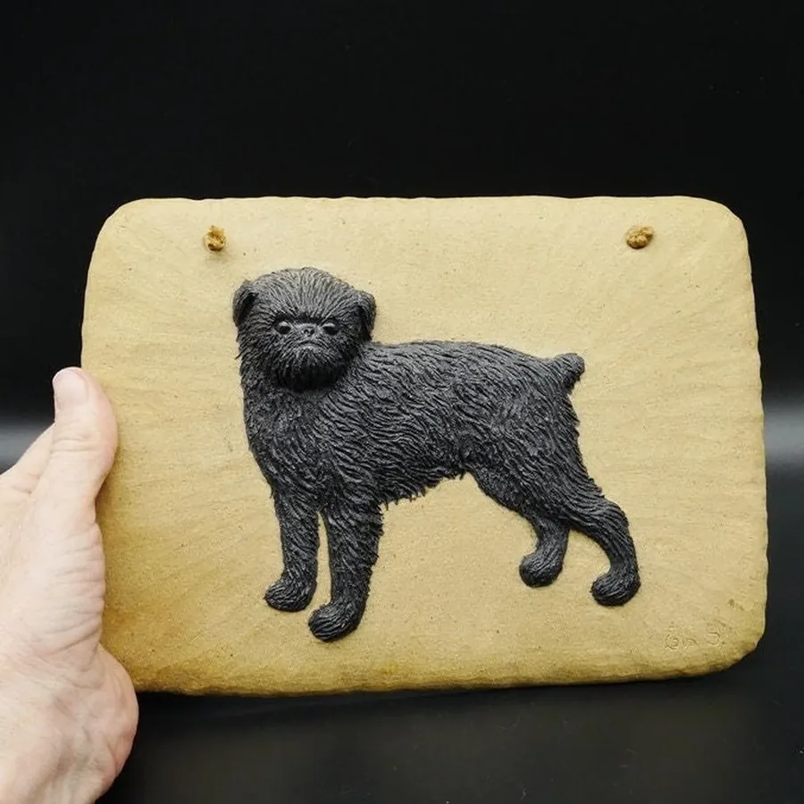Vintage Swedish ceramic wall tile with 3D black dog relief on natural wood base, held in hand