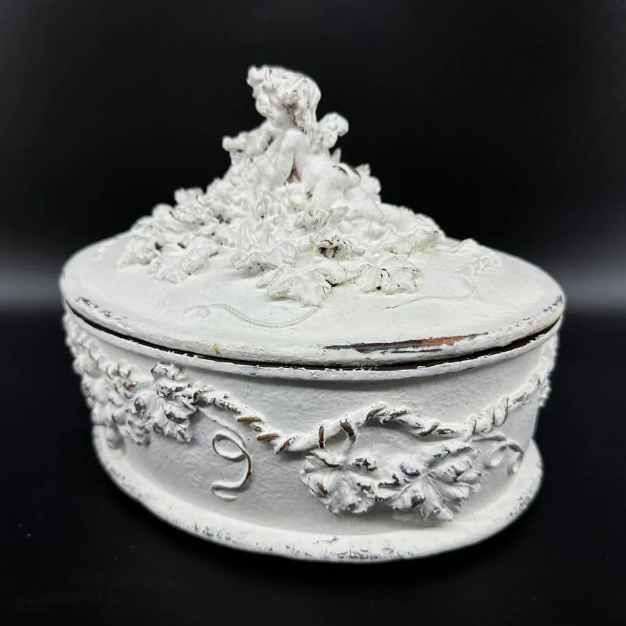 White Rococo cherub box with layered relief carving, side profile showing ornamental border detail