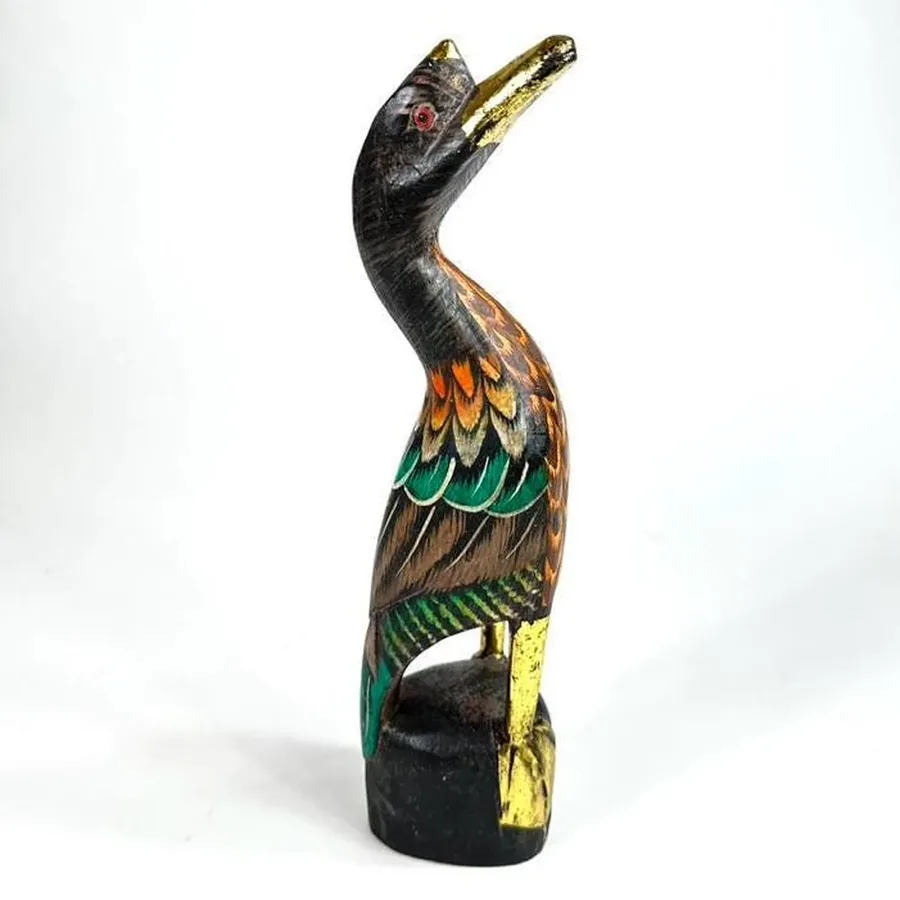 Wooden duck figurine's body profile showing curved silhouette and hand-painted plumage texture