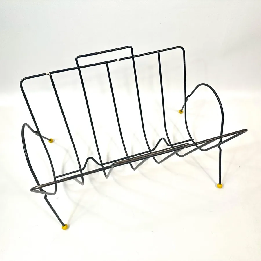 1960s wire rack rear angle view showing architectural framework, support wires, and yellow ball foot placement