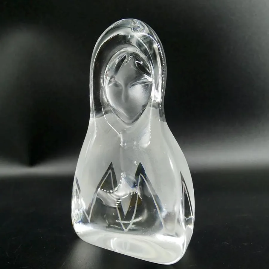 Angled side view of crystal glass sculpture showing three-dimensional engraving depth and frosted glass transition