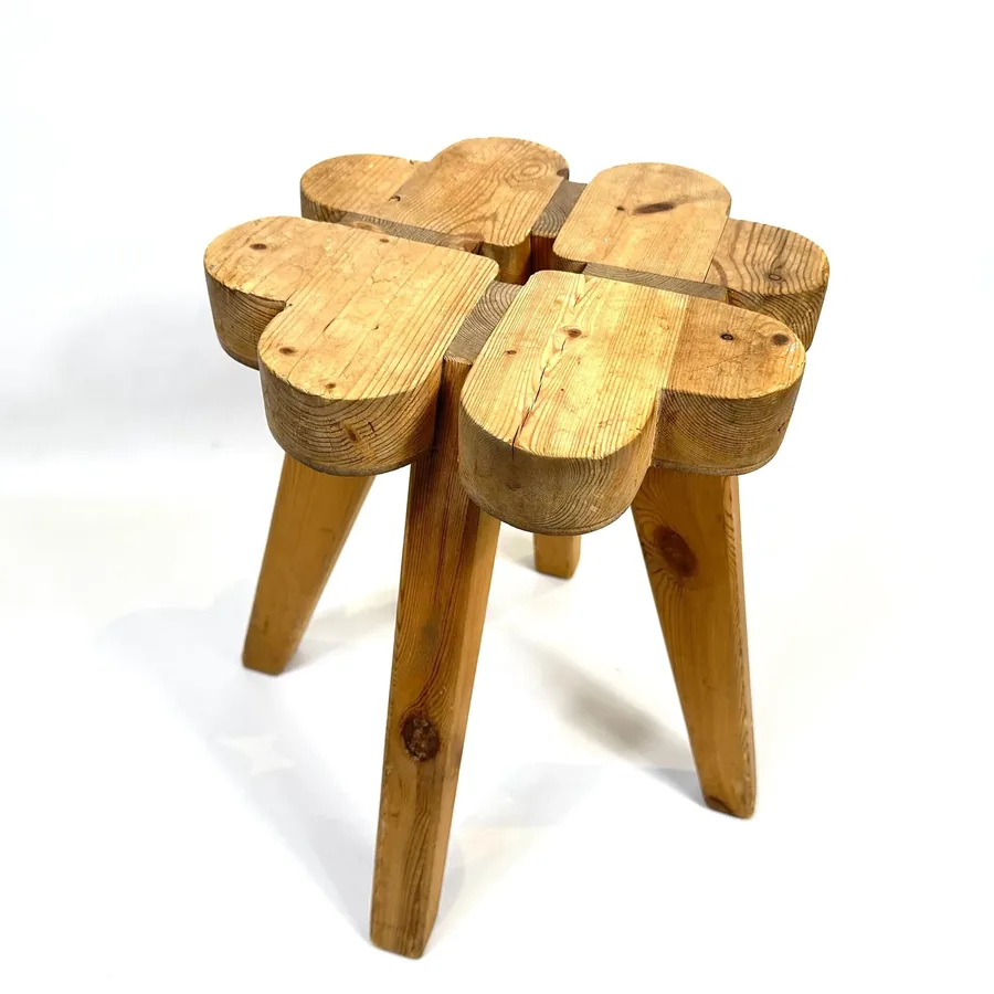 Angled side view of solid wood stool highlighting tapered leg construction and seat block assembly
