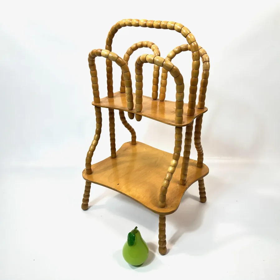 Angled view with pear showing scale of Swedish vintage wooden magazine rack with rotating bead frame