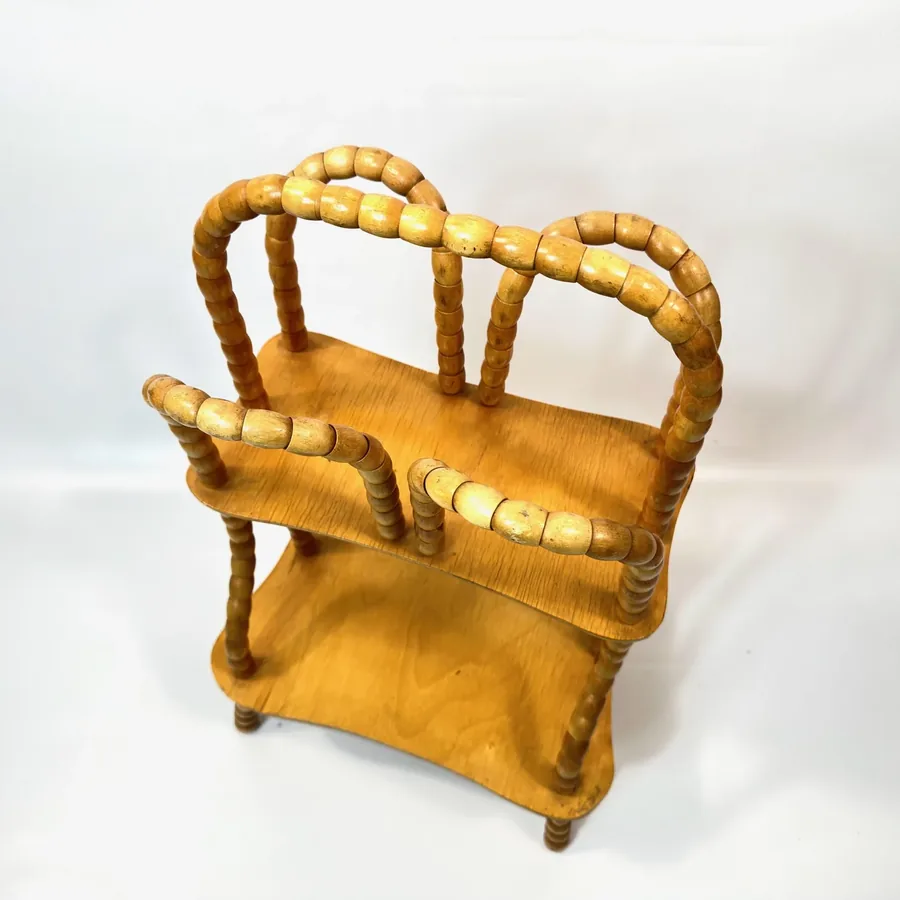 Close-up front view of wooden magazine rack showing individual rotating beads and two-tier shelf configuration