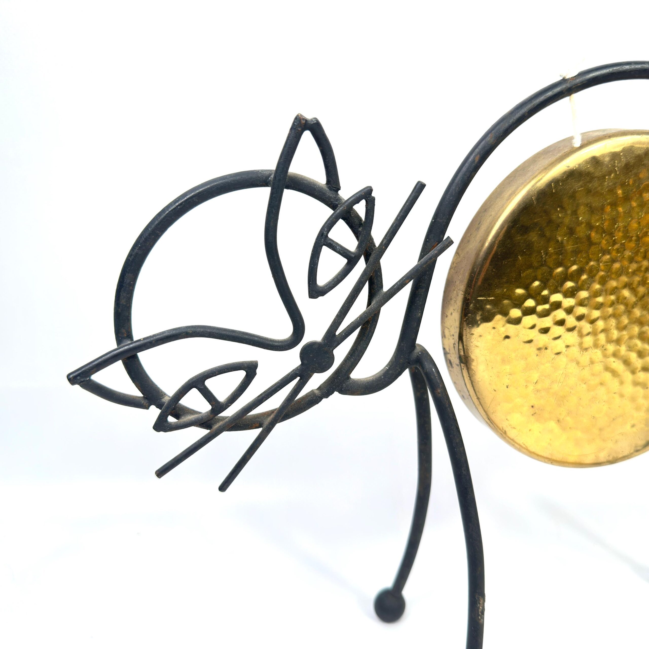 Close-up of wrought iron cat head showing detailed leaf vine work and connection to main gong bowl structure