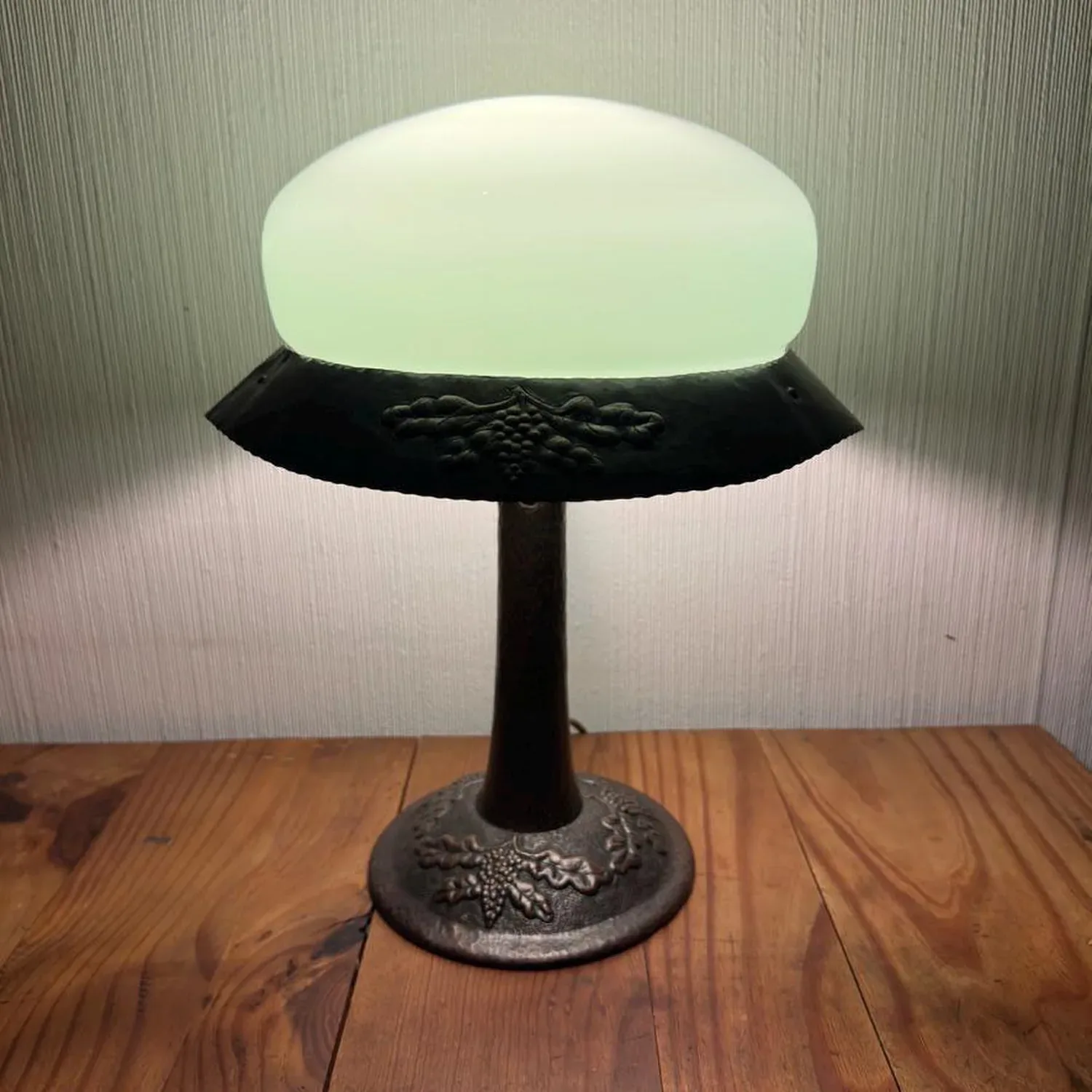 Early 20th century Arts & Crafts hammered copper table lamp with pale green glass dome shade and textured metal base, full vi