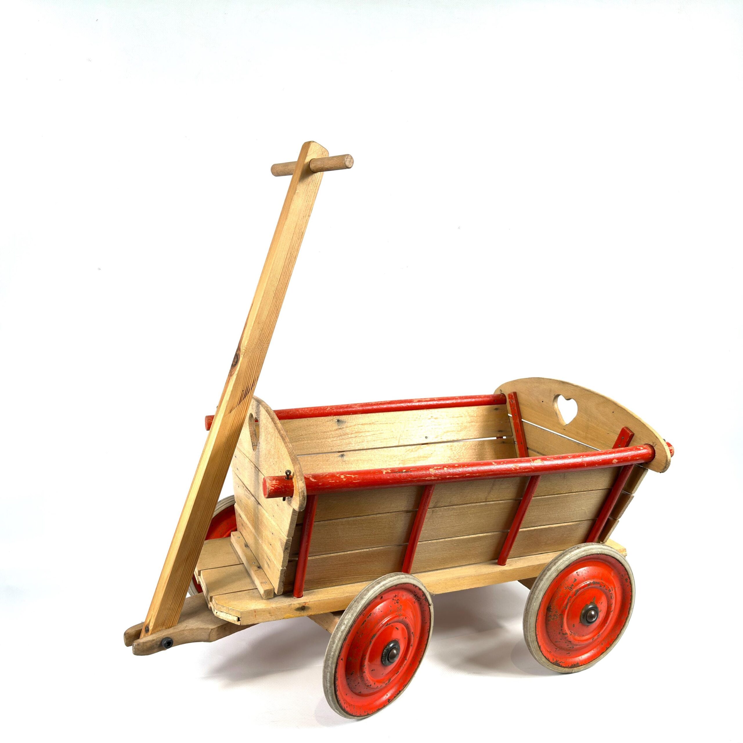 Empty wooden toy wagon side profile, showing curved red-rimmed sides, wooden handle, and large red metal wheels
