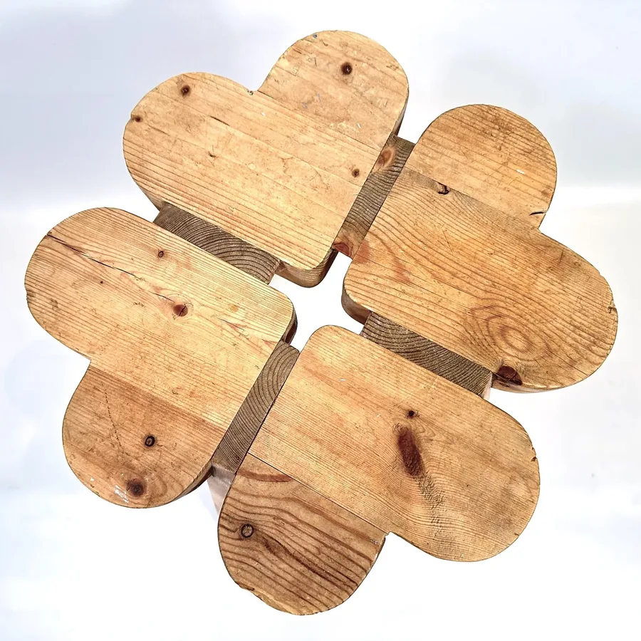 Flat lay of wooden stool seat showing six individual blocks assembled into clover pattern, top surface detail