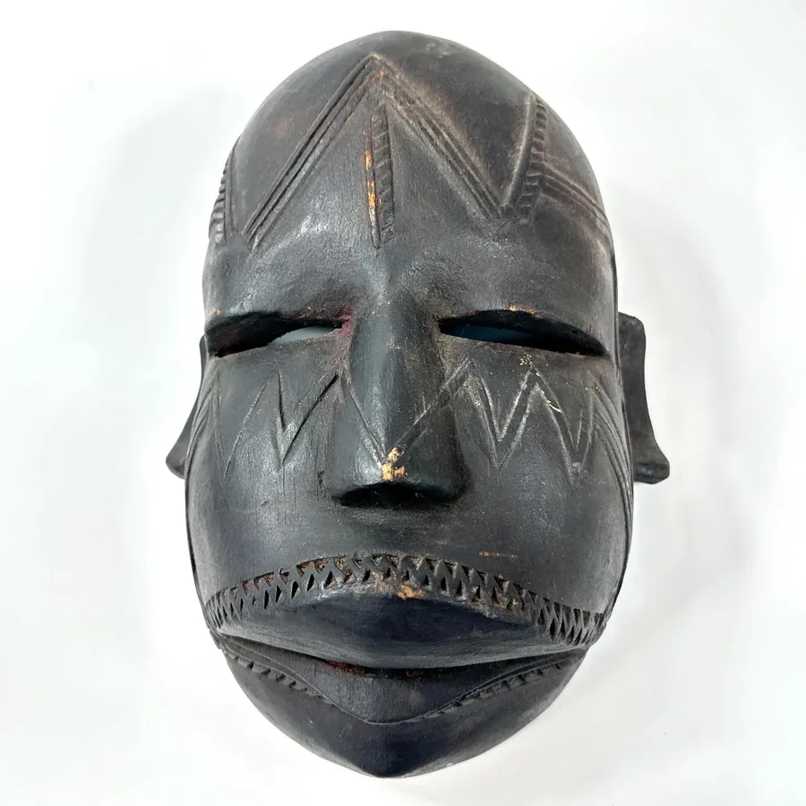 Front-center mask view with emphasis on expressive facial features, geometric forehead markings, striped mouth design, dark w