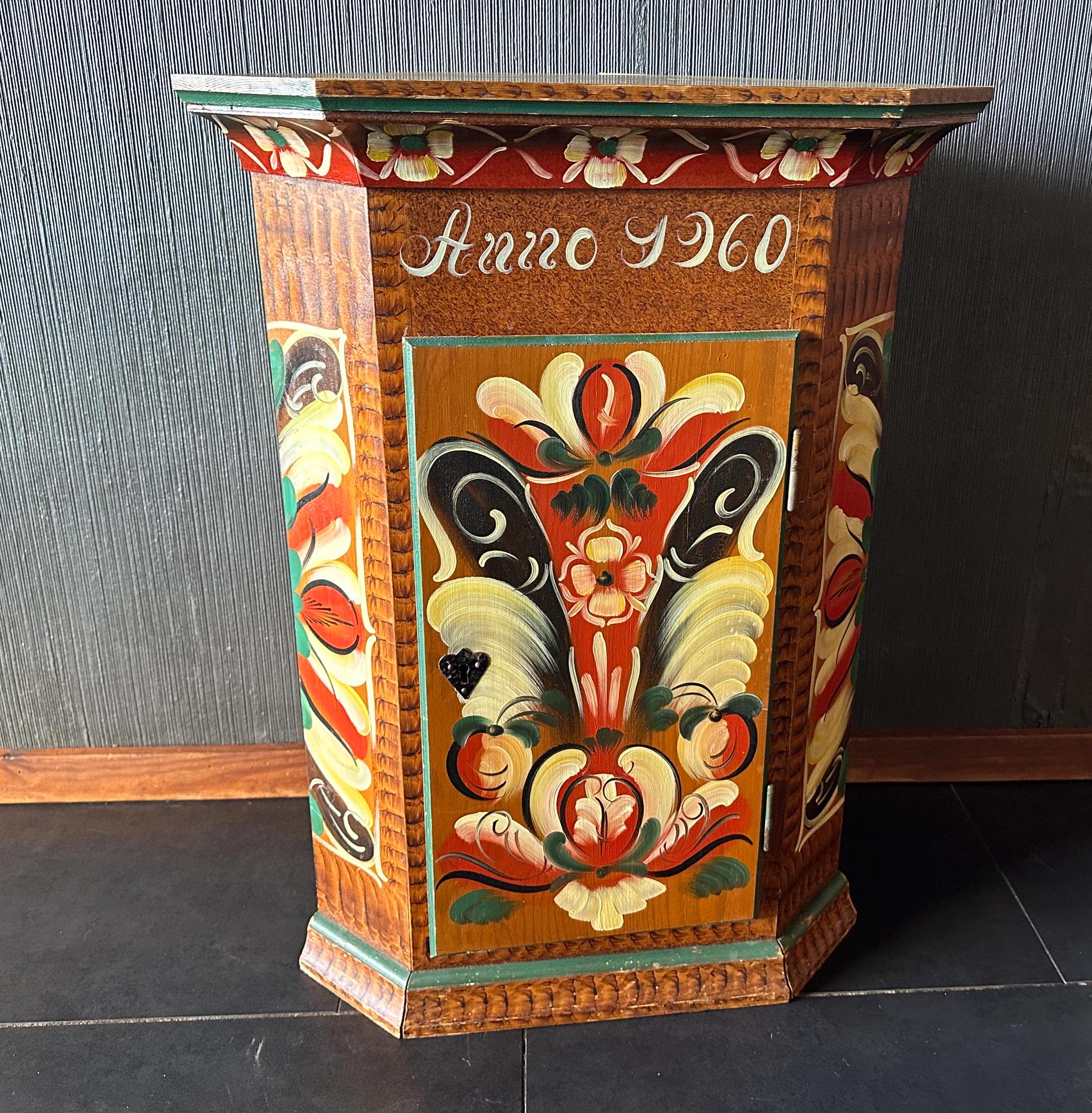 Front-center view of complete painted cupboard showing symmetrical Kurbits pattern with central floral arrangement and decora
