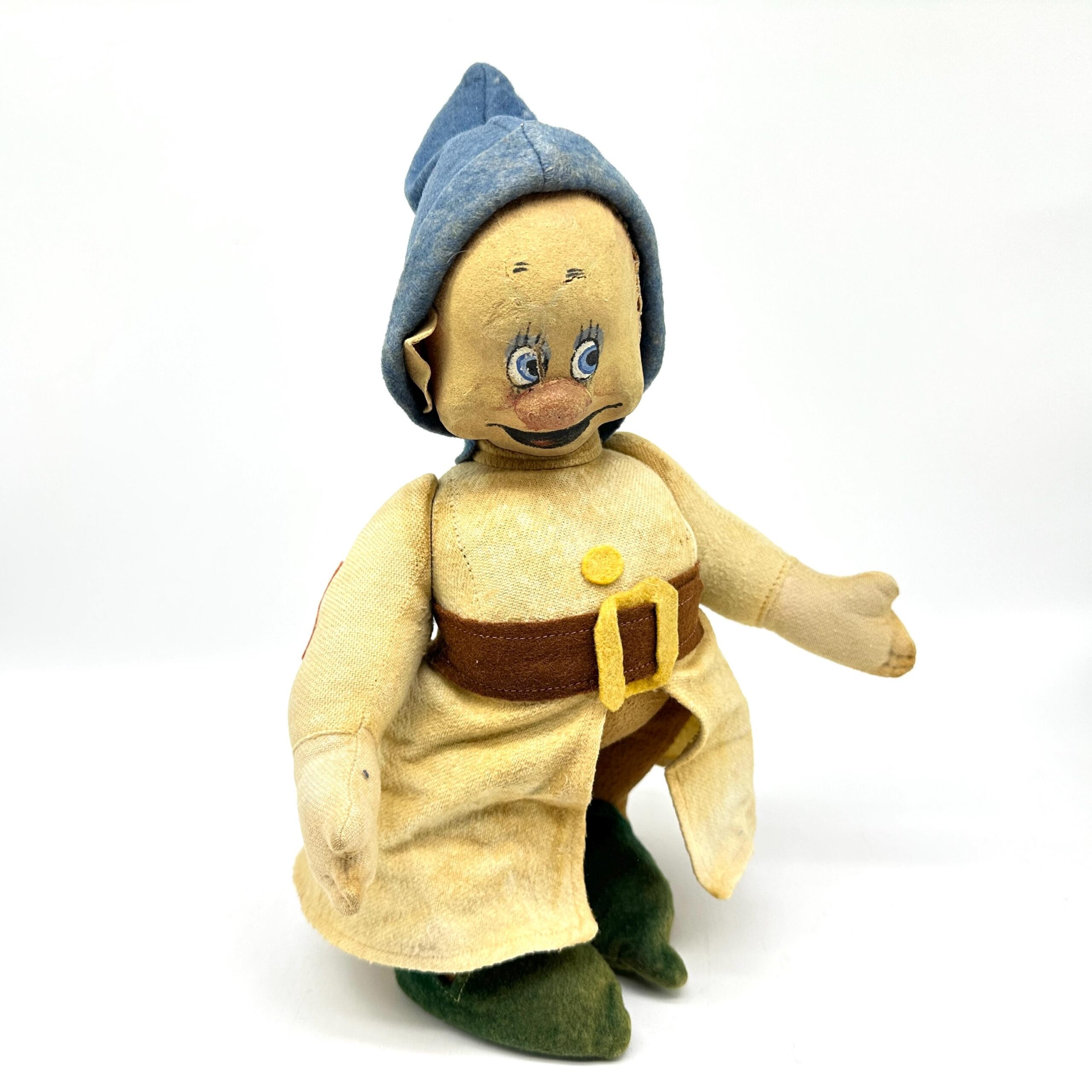 Front-facing dwarf doll with both arms relaxed, detailed view of painted smile and eye expression, blue hood, yellow dress wi