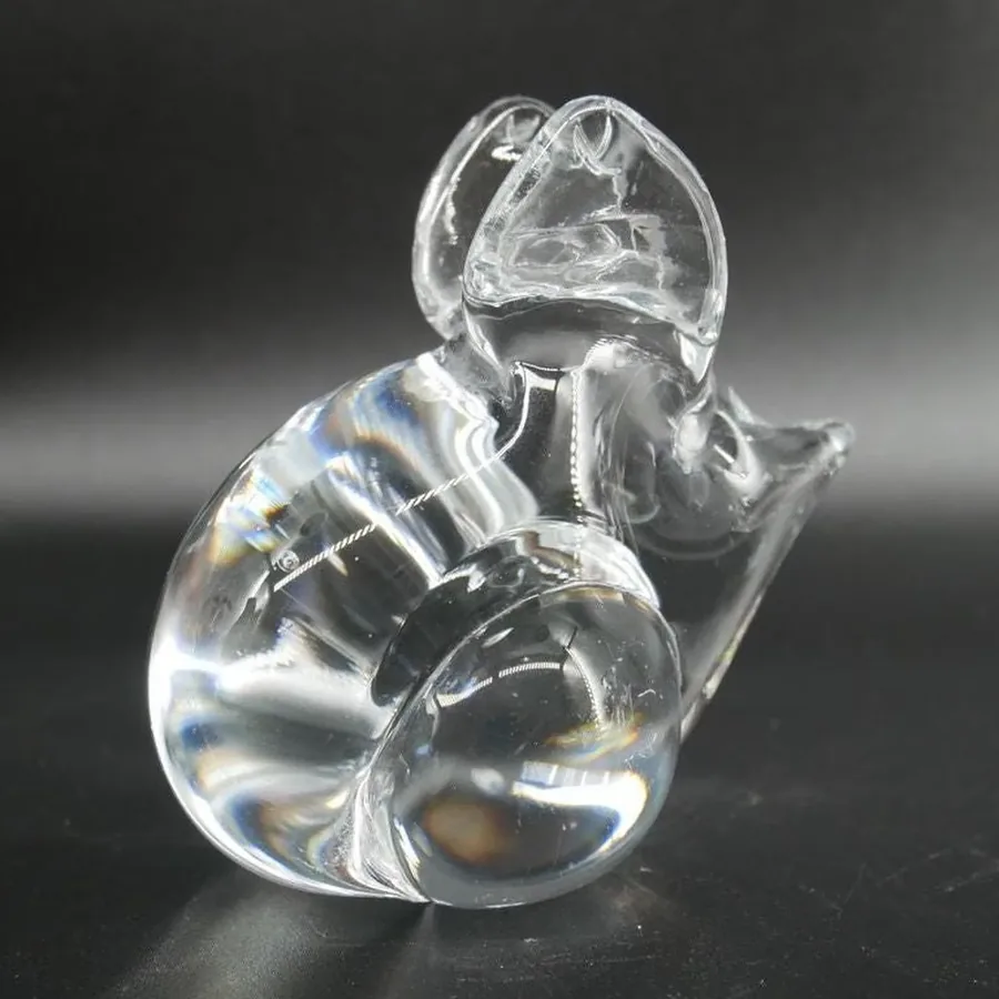 Glass mouse positioned at angle showing pointed snout and smooth curved back, minimalist studio lighting