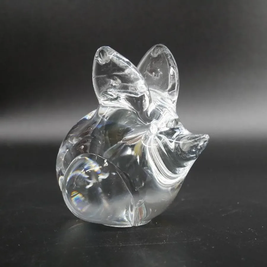 Glass mouse sculpture from low angle showing rounded body and nose-forward posture, minimalist composition