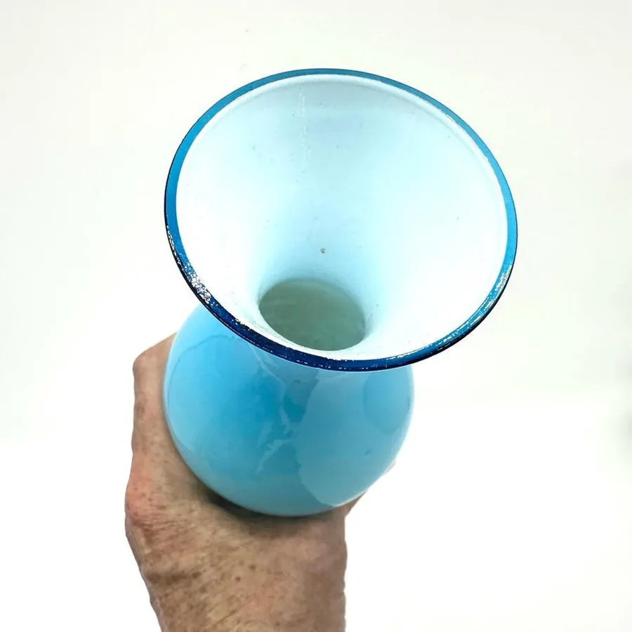 Hand-held interior view showing open rim, pristine white opaline interior surface, and clear glass depth without casing