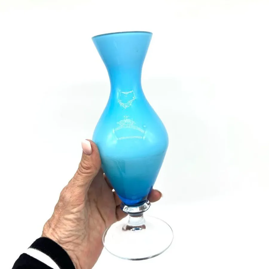 Held vase angle showing three-quarter view, casing luminosity, curved body contours, and clear pedestal construction