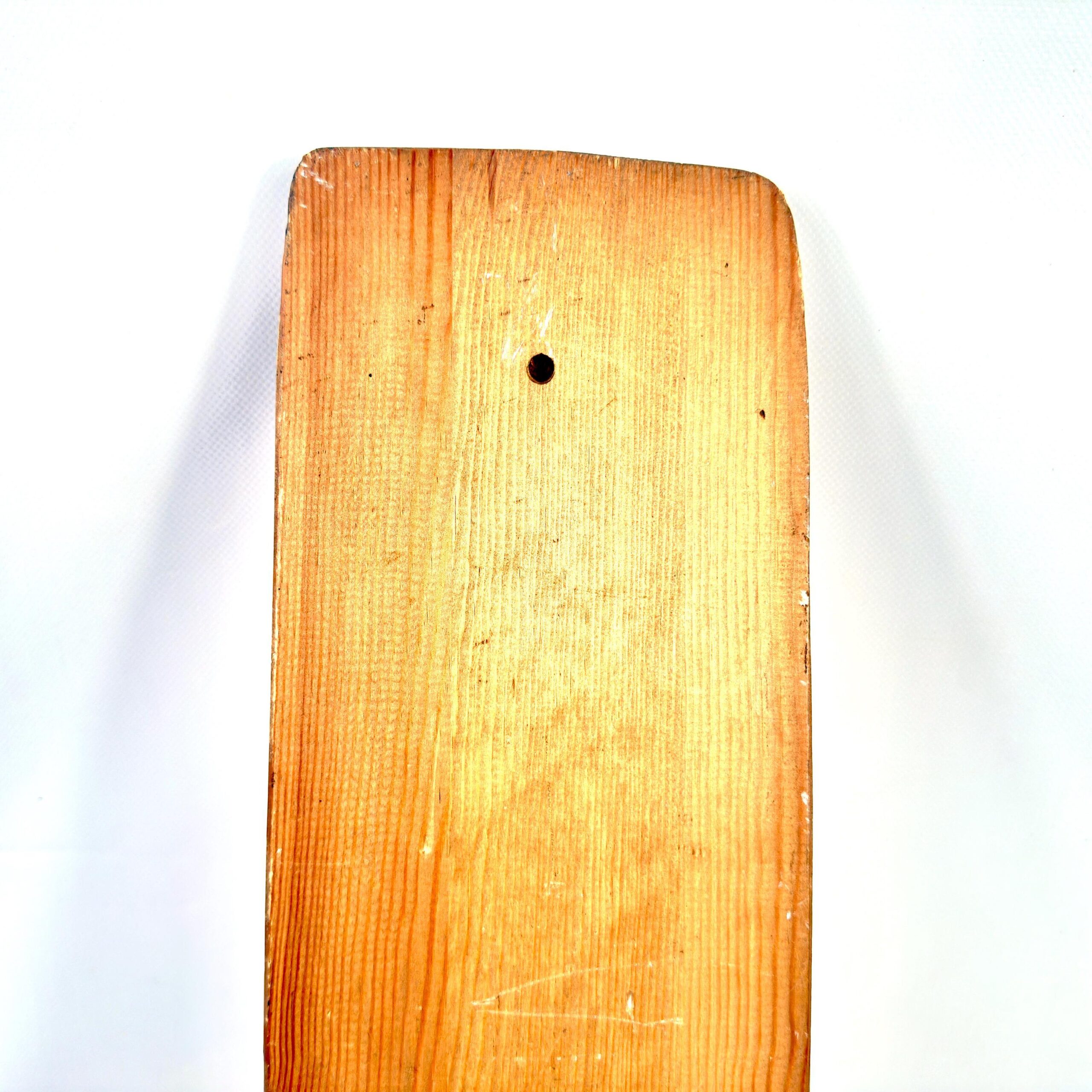 Wood texture detail showing grain patterns, age cracks, and patina coloring of antique mangling board