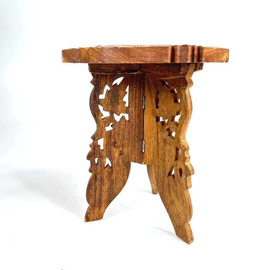 Minimalist side view of wooden tripod showing clean leg structure and scalloped tabletop edges against white background