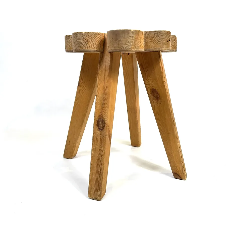 Minimalist straight-on view of wooden stool emphasizing clean lines and four angled support legs