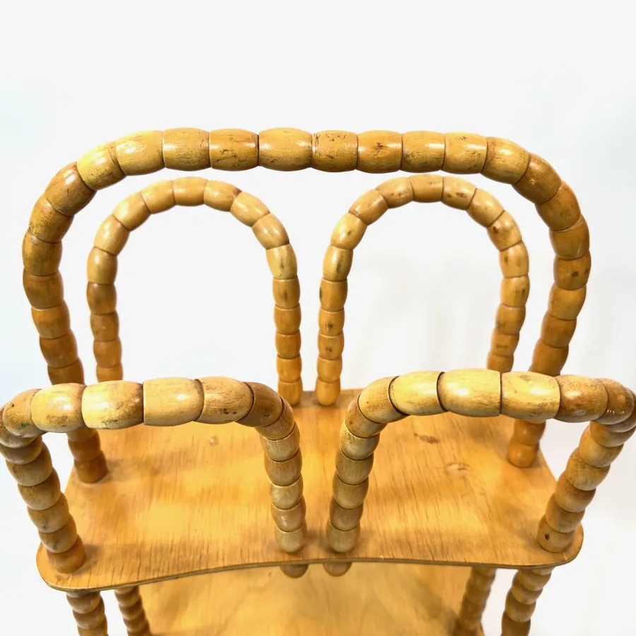 Overhead detail shot of rotating bead construction and top frame of vintage wooden magazine storage rack