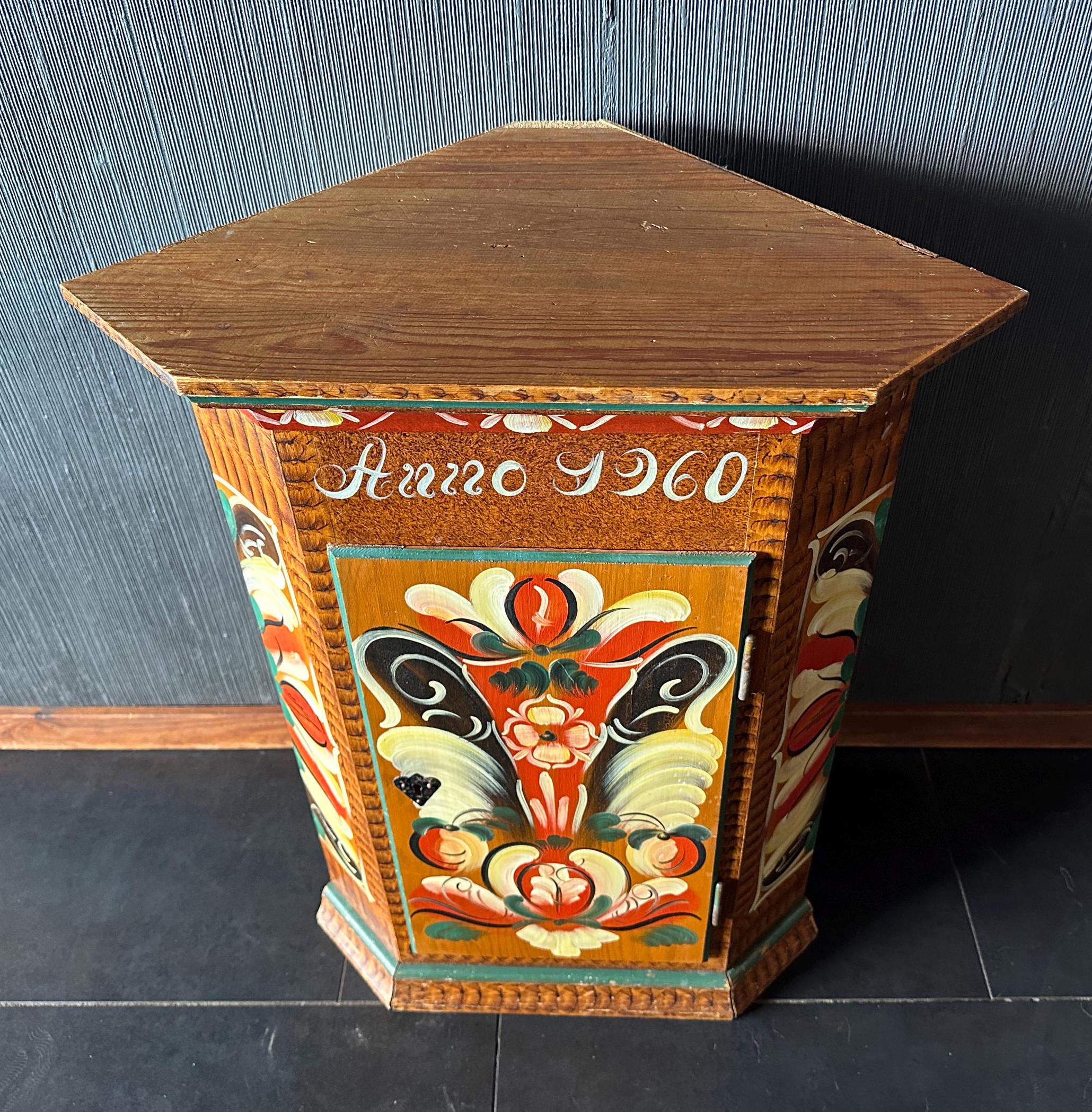 Overhead three-quarter view of corner cupboard showing peaked crown, painted top surface, and depth of hand-painted decoratio