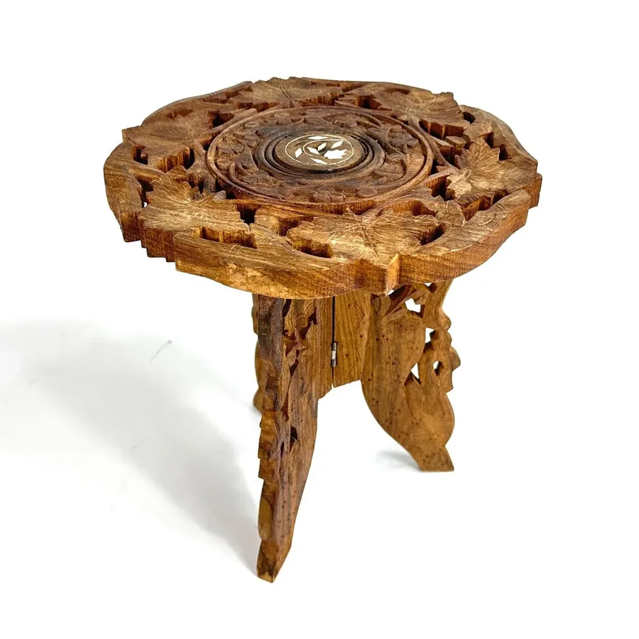 Overhead view of carved wood plant stand showing detailed floral center medallion and scalloped edge design